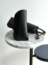 Load image into Gallery viewer, 68f6623ec600065f8f92bc31_eyewear-case-raven_1764360501351.jpeg
